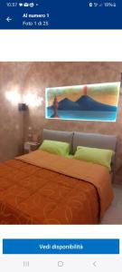 una camera da letto con un letto e un dipinto sul muro di Al numero 1 a Napoli