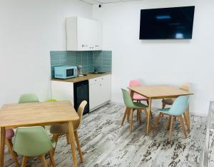 a room with two tables and chairs and a kitchen at Pisos viajer@s in O Grove
