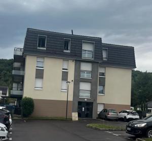 Un edificio con coches aparcados en un estacionamiento. en Appartement 50m2 Amnéville avec balcon à 2 min des thermes, en Amnéville