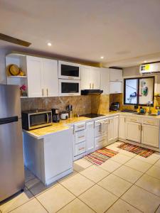 a kitchen with white cabinets and a refrigerator at Pipas Apartment I Walk to the beach in Tamarindo
