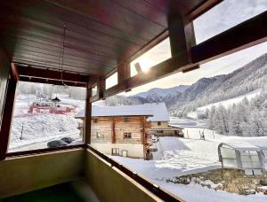 Una habitación con una ventana con vista a una montaña cubierta de nieve. en CASA-Bois de Pisan au pied des pistes, en Molines-en-Queyras