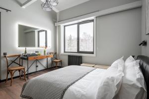 a bedroom with a bed and a desk and a mirror at Vasara in Rušenīca