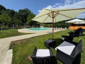 a group of chairs and an umbrella next to a pool at Agriturismo Tre Elle in Acri