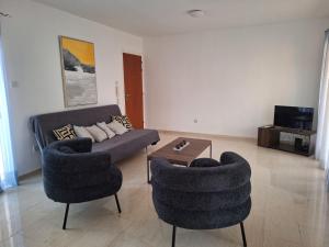 a living room with two chairs and a couch at City Sunshine, Strovolos - Nicosia in Nicosia
