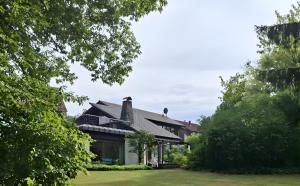 an exterior view of a house with trees at Ferienhaus mit Schwimmhalle in Burgthann