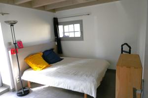 a small bedroom with a bed with a window at Charmante maison de campagne Limousin-Périgord 