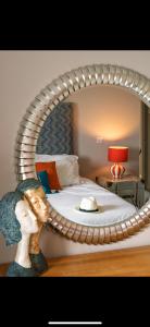 a bedroom with a bed with a large circular mirror at FERRYPOINT - 3 Bed Stylish Beachfront Retreat in Padstow