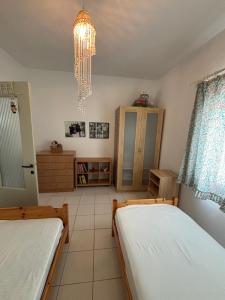 a bedroom with two beds and a chandelier at Pebble Sea House in Orfánion