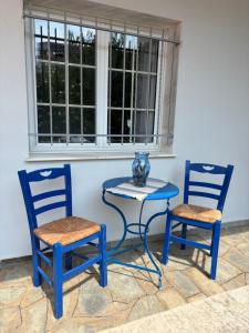 two blue chairs and a table with a vase on it at Pebble Sea House in Orfánion