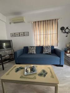 a living room with a blue couch and a coffee table at Pebble Sea House in Orfánion