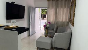 a living room with two chairs and a table and a television at Mami Yola in Valledupar