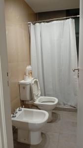 a bathroom with a white toilet and a sink at Departamento Lake Towers in Villa Carlos Paz