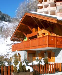a building with a balcony in the snow at Casa-Chalet du Merle N° 1 in Champagny-en-Vanoise