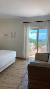 a bedroom with a bed and a view of the ocean at Vila Antic in Almancil +29 photos