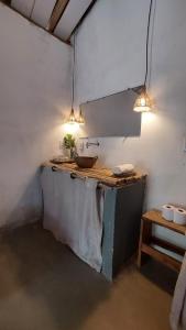 ein Badezimmer mit Waschtisch, Waschbecken und Beleuchtung in der Unterkunft Quintal do Céu Caraíva in Caraíva