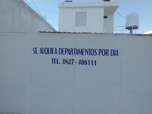 a sign on the side of a white wall at Departamentos Aimogasta Vientos in Arauco