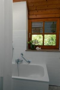 a bathroom with a white tub and a window at Ferienhaus Fischermartl am Ammersee in Dießen am Ammersee +10 photos