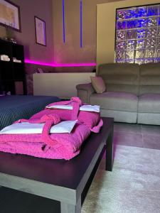 a living room with a pink blanket on a table at TownHouse Piraino SUITE PRIVATE SPA in Brolo +40 photos