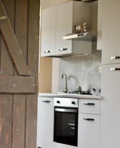 a kitchen with white cabinets and a sink and an oven at Casa Antele in Quartu SantʼElena +51 photos