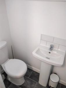 a white bathroom with a toilet and a sink at City breaks Corby Uist Walk in Rockingham