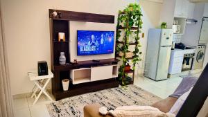a living room with a tv and a kitchen at Loft On Grosvenor in Pretoria