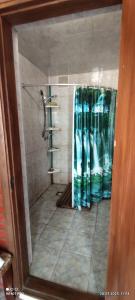 baño con ducha con cortina verde en Дом у моря, en Chornomorsk