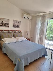 a bedroom with a bed and a large window at House by the sea in Kalamáki