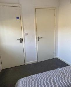 two white doors in a room with a bed at City breaks Corby Uist Walk in Rockingham +12 photos