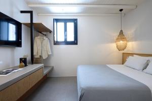 a bedroom with a bed and a dresser and window at ANOTERRA VILLAS -Astris in Ambelas +52 photos