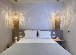 a bedroom with a large bed with two white pillows at ANOTERRA VILLAS -Astris in Ambelas