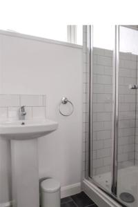 a white bathroom with a sink and a shower at City breaks Corby Uist Walk in Rockingham