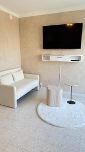 a living room with a couch and a flat screen tv at Entre Ciel&Mer in Palavas-les-Flots