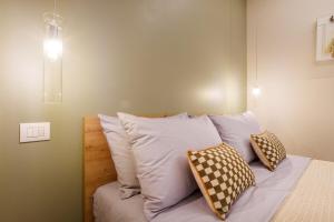 Bett mit vier Kissen auf einem Zimmer in der Unterkunft Urban Eden Nest - Smart Oasis in the Motor Valley in Modena