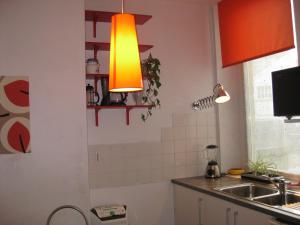 a kitchen with an orange light hanging over a sink at city-break in Épinal