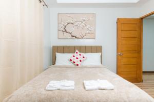 a bedroom with a bed with two towels on it at CasaPrincesa near Honda Bay Island in Puerto Princesa City