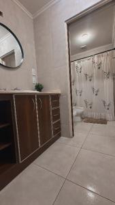 a bathroom with a sink and a toilet and a mirror at La Colorada Dolores in Dolores