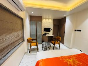 a hotel room with a bed and a desk and chairs at Hotel Sun-n-Moon in Shirdi