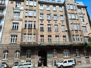 a large building with cars parked in front of it at Apartament Narutowicza 56 in Łódź