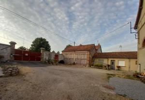 an empty street with a house and a barn at Gîte de la Queune 4 pers in Souvigny