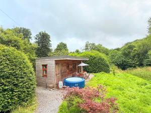 a small shed with a hot tub in a garden at The Natures Nook With HotTub in Talog