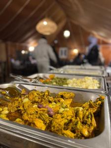 a row of trays of food on a buffet at Desert Nights Camp in Merzouga +51 photos