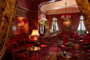 Cette chambre dispose d'un bar avec des chaises et des tables rouges. dans l'établissement Hôtel Raphael, à Paris