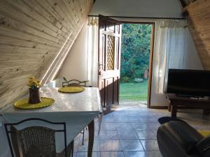 a room with a table with chairs and a television at Recanto Efraim in Tapiraí