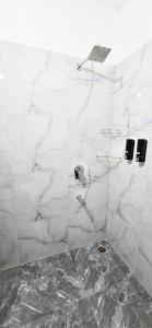 a bathroom with a shower with white marble walls at Luxury Apt with Mountain View in Jāmb