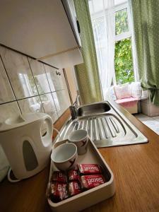 a kitchen counter with a tray of soda cans and a sink at Cozy small apartment in Vienna