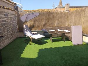 a patio with a chair and a table on the grass at appartements familial in Vias