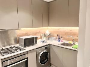 a kitchen with a washing machine and a microwave at The Damac apartment in Amman