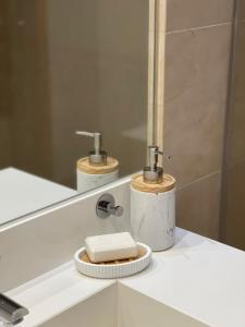 a bathroom with a sink with a soap dispenser and a mirror at Apartamento Vista Marinha in Portimão