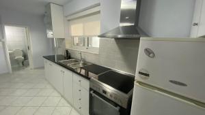 a kitchen with a stove and a sink and a refrigerator at Relax in Loutraki in Loutraki