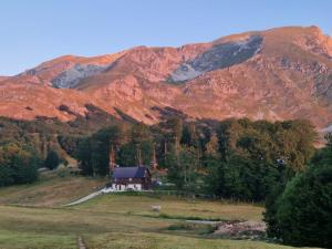 una casa su una collina di fronte a una montagna di GUEST HOUSE PRIVAL.CLUB a Žabljak